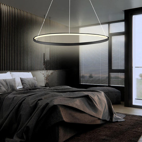 Black LED ring chandelier installed above bed in modern bedroom interior.