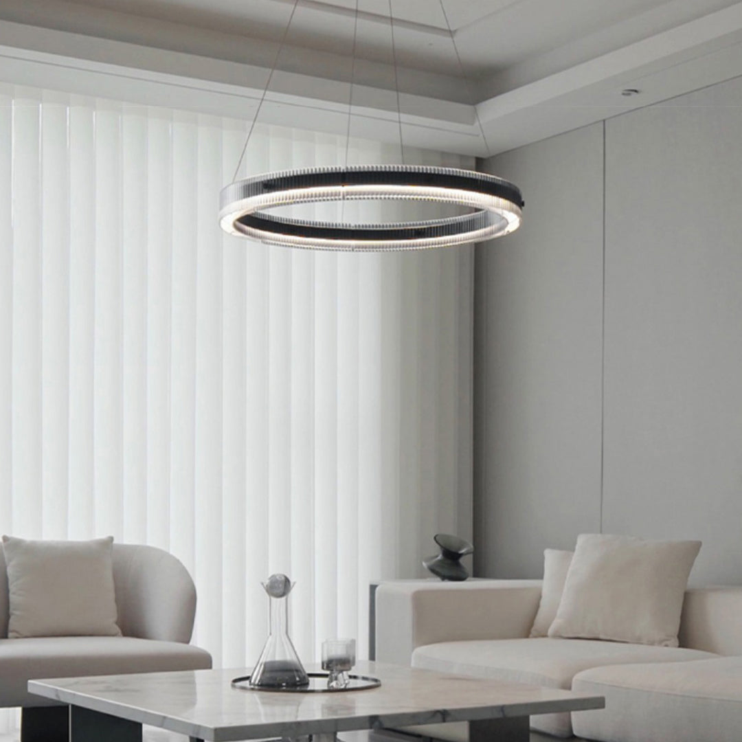 Contemporary black round pendant light providing ambient lighting in minimalist white interior