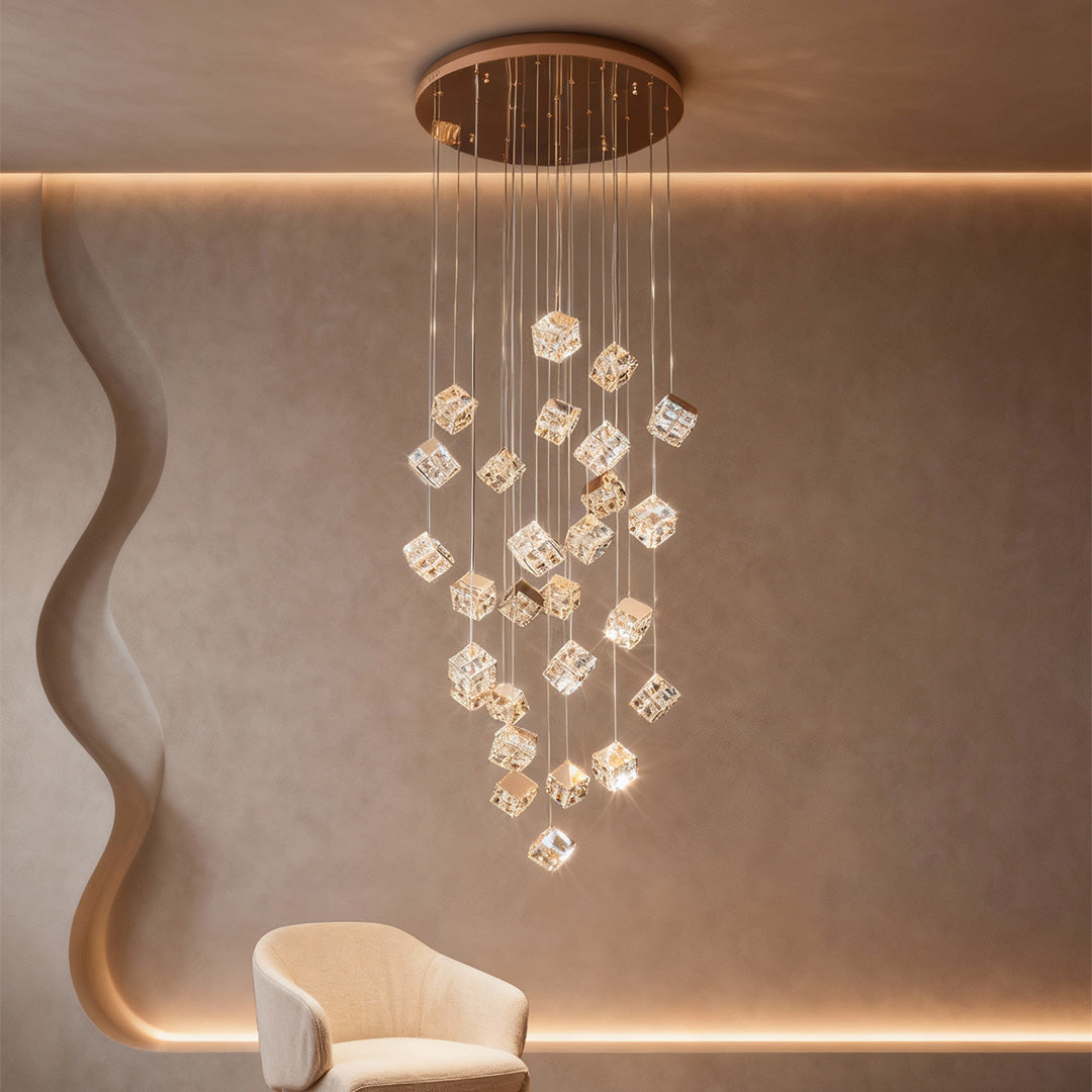 Contemporary gold stairs chandelier glowing above curved wall and bench.