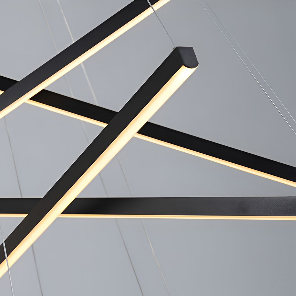 Criss linear chandelier in gold and black, suspended above a modern dining table for sophisticated lighting.