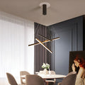 Criss linear chandelier featuring sleek gold and black lines, illuminating a contemporary living room.