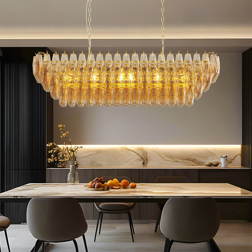 Rectangular glass pendant chandelier with amber tones lighting up a luxury dining area.