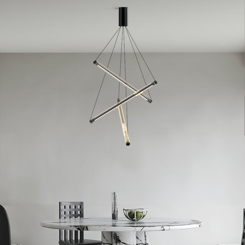 Minimalist LED linear chandelier with three intersecting gold bars and hanging thin cables in a modern dining room.
