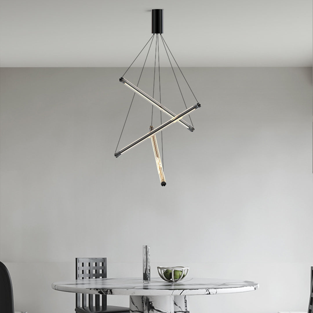 Minimalist LED linear chandelier with three intersecting gold bars and hanging thin cables in a modern dining room.
